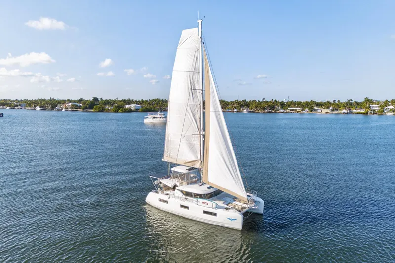 Slide: The Image of 2021 Lagoon 46 Owner's Version sailing on calm waters under a clear blue sky. - 114
