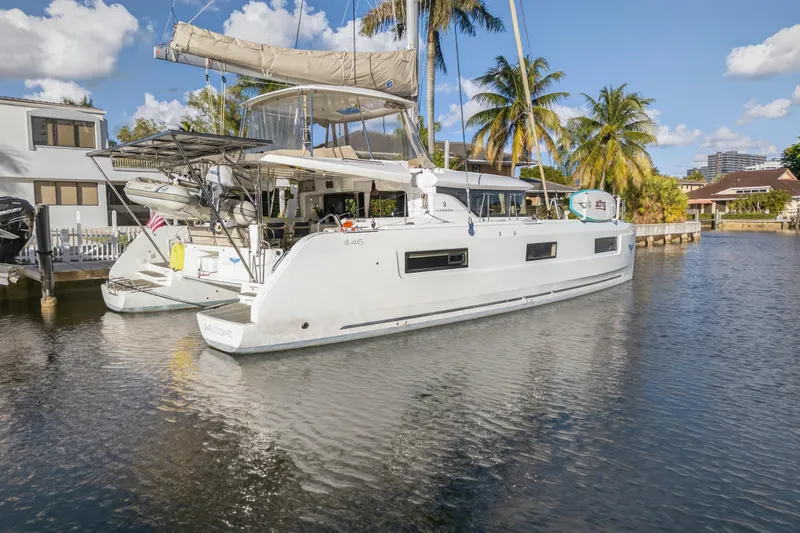 Slide: The Image of 2021 Lagoon 46 Owner's Version catamaran docked in a sunny marina setting. - 115