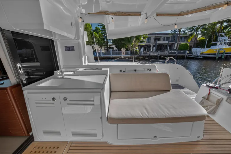 Slide: The Image of Luxurious Lagoon 46 Owner's Version yacht interior with seating and kitchenette, 2021 model. - 19