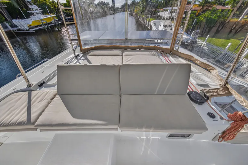 Slide: The Image of Luxurious seating area on 2021 Lagoon 46 Owner's Version catamaran, docked by a scenic canal. - 33