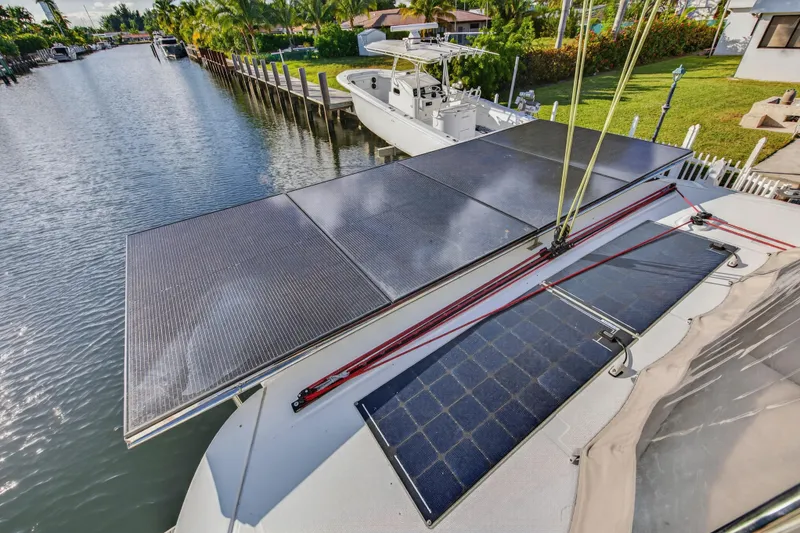 Slide: The Image of 2021 Lagoon 46 Owner's Version catamaran with solar panels on deck, docked by a canal. - 47