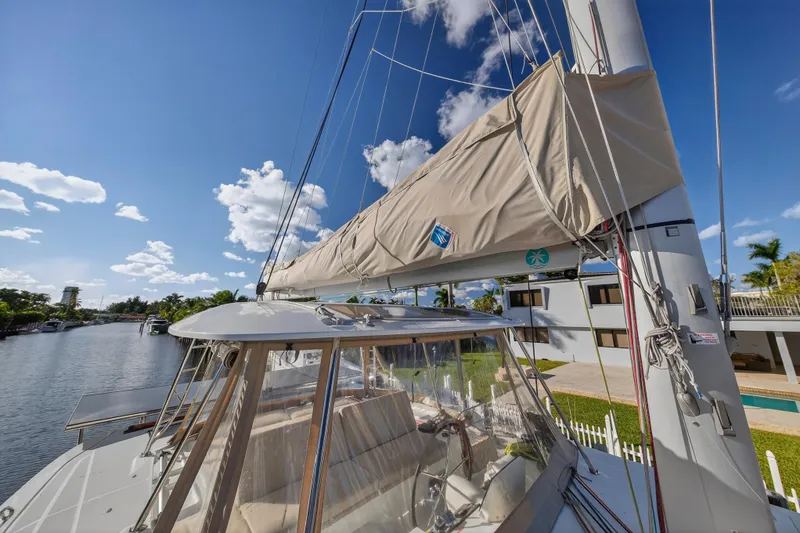 Slide: The Image of 2021 Lagoon 46 Owner's Version catamaran docked by a scenic waterfront. - 49