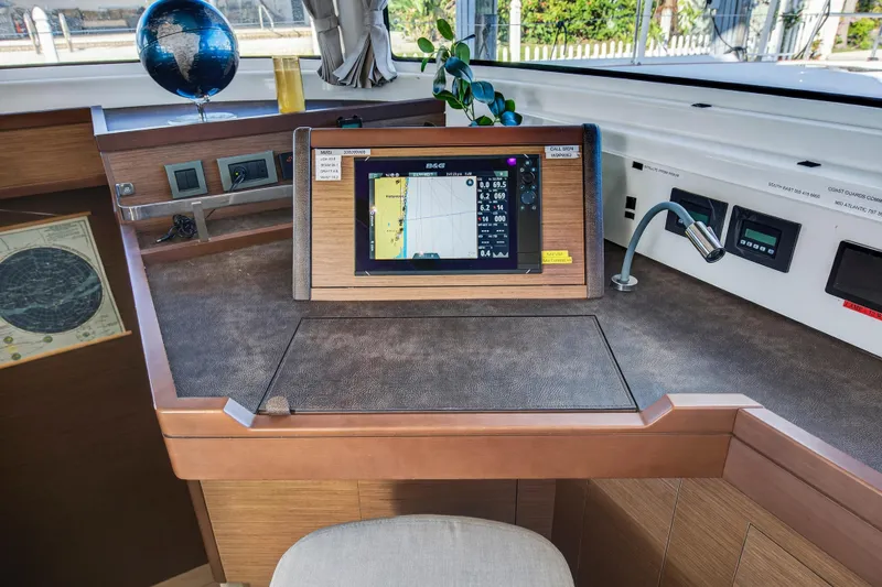 Slide: The Image of Navigation station of 2021 Lagoon 46 Owner's Version catamaran with chart plotter and globe. - 60