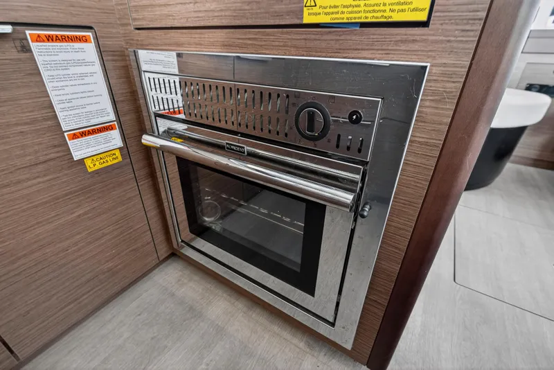 Slide: The Image of Built-in oven in Lagoon 46 Owner's Version yacht, 2021 model, with safety warnings. - 68