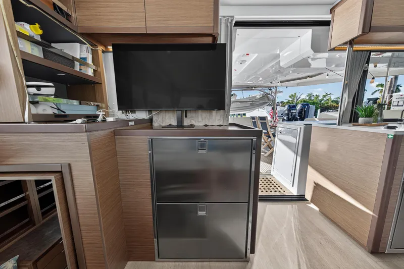 Slide: The Image of Interior of 2021 Lagoon 46 Owner's Version yacht with modern kitchen and outdoor view. - 70