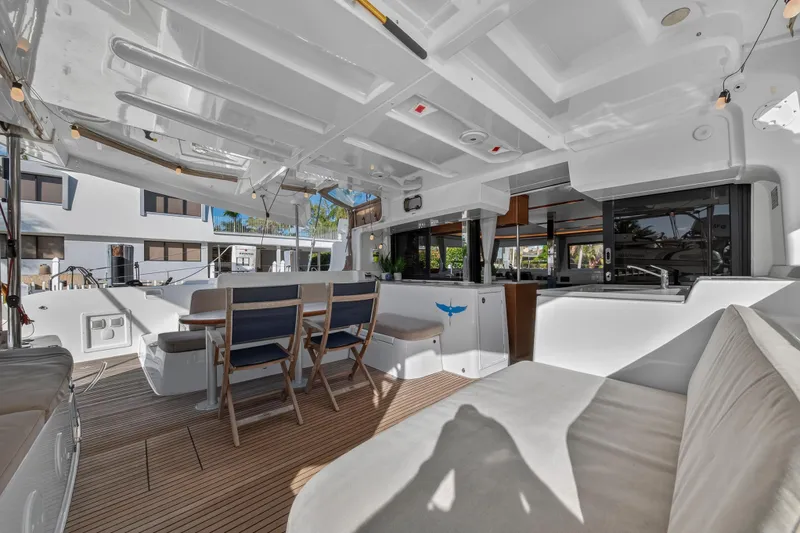 Slide: The Image of Spacious interior of 2021 Lagoon 46 Owner's Version catamaran with modern seating and dining area. - 9
