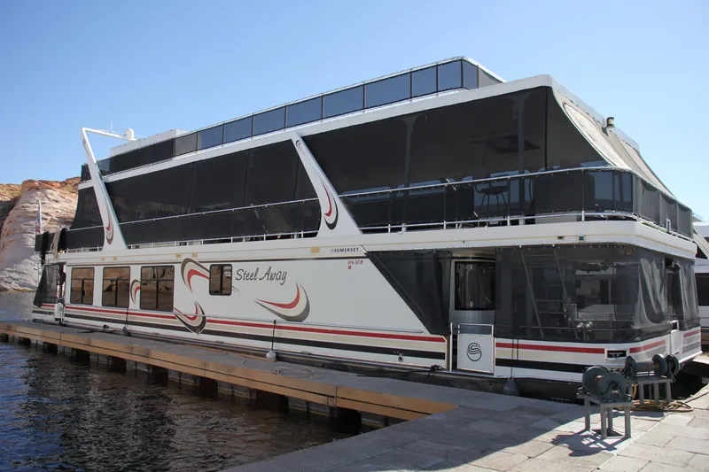The Image of 2007 Sumerset Steel Away houseboat docked, featuring modern design and spacious upper deck. - 1