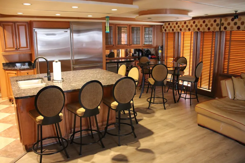 Slide: The Image of Luxurious 2007 Sumerset Steel Away houseboat kitchen with island, bar stools, and modern appliances. - 8