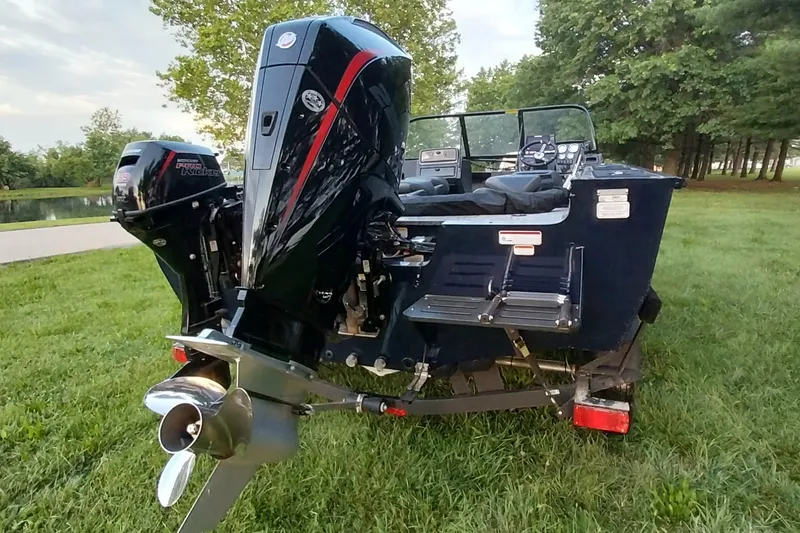Slide: The Image of 2025 Tracker Targa V-19 WT boat with powerful outboard motor on grassy area. - 21