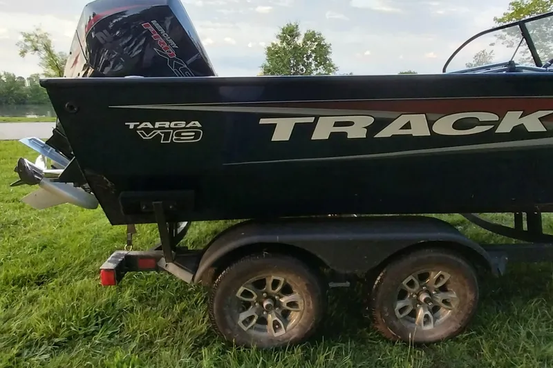 Slide: The Image of 2025 Tracker Targa V-19 WT boat on trailer, parked on grass. - 22