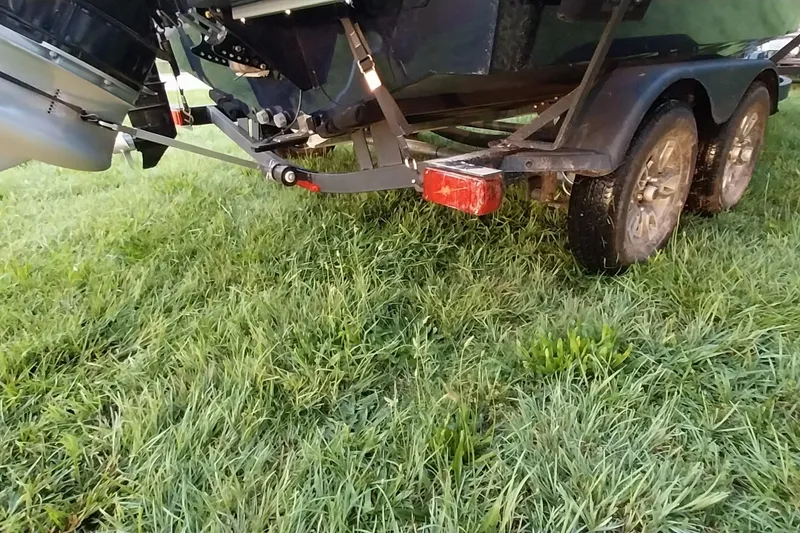 Slide: The Image of Trailer of 2025 Tracker Targa V-19 WT boat on grassy field. - 23