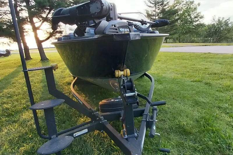 Slide: The Image of 2025 Tracker Targa V-19 WT boat on trailer, parked on grassy area near trees. - 29