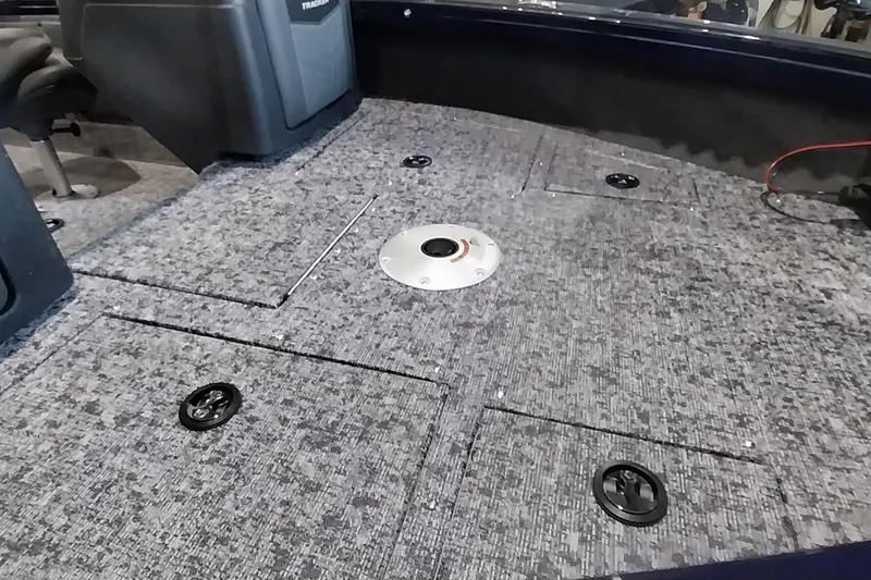 Slide: The Image of 2025 Tracker Targa V-19 WT boat interior with carpeted deck and storage compartments. - 3