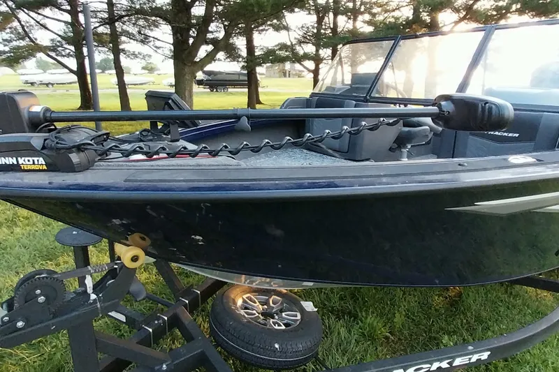 Slide: The Image of 2025 Tracker Targa V-19 WT boat on trailer, parked outdoors near trees. - 31