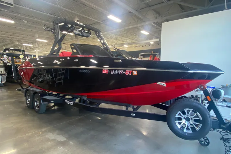 The Image of 2019 Axis A24 boat in showroom, black and red design on trailer. - 1
