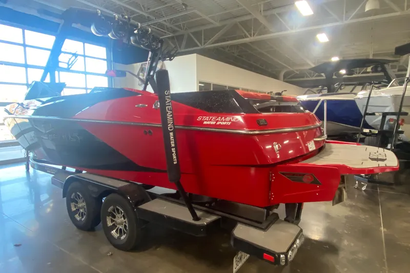 Slide: The Image of Red 2019 Axis A24 boat on trailer in showroom, featuring sleek design and modern features. - 26