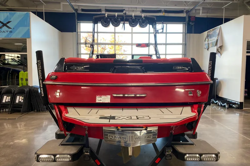 Slide: The Image of 2019 Axis A24 boat, red, rear view in showroom with wakeboard tower. - 27