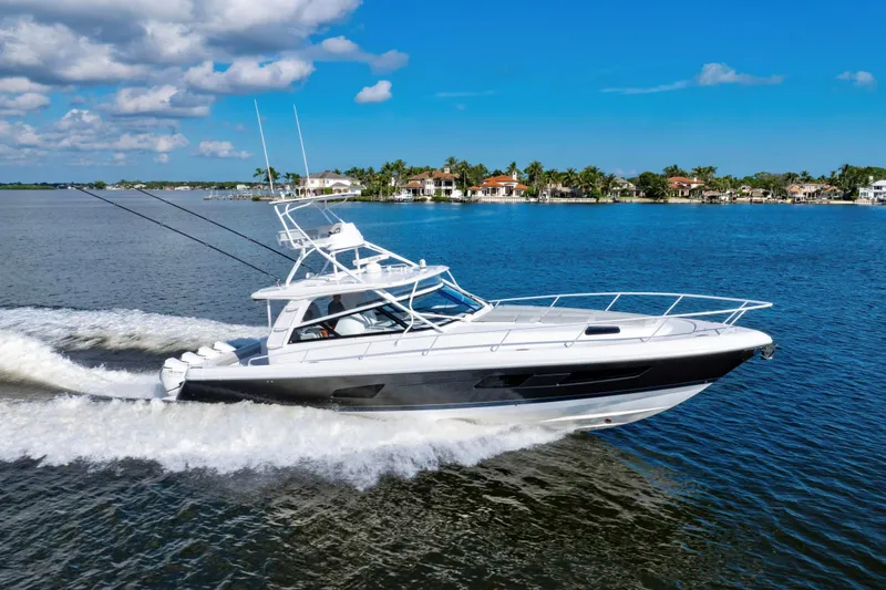 The Image of 2022 Intrepid 477 Evolution cruising on a sunny day near waterfront homes. - 0