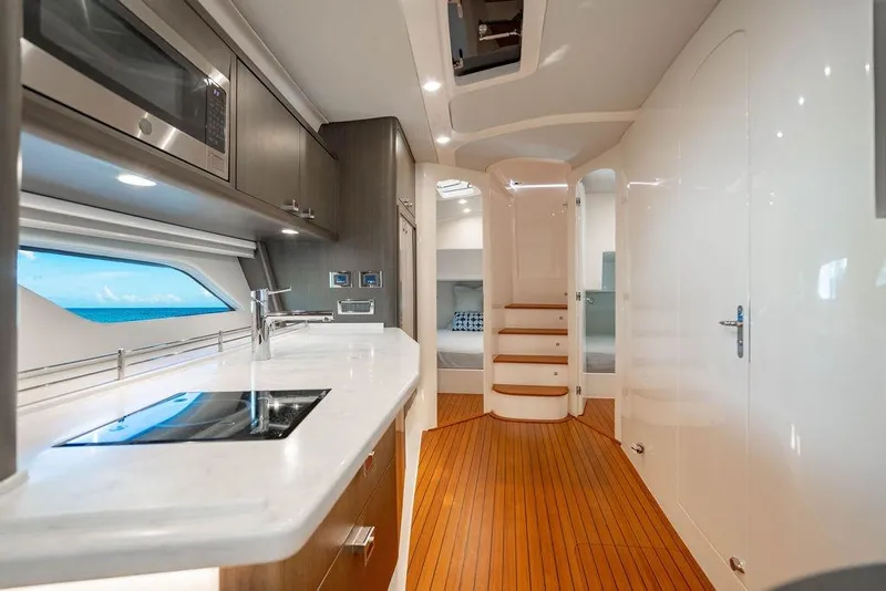 Slide: The Image of Luxurious interior of 2022 Intrepid 477 Evolution yacht with modern kitchen and wooden flooring. - 16