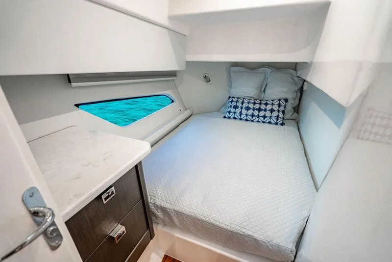 Slide: The Image of Cozy cabin interior of 2022 Intrepid 477 Evolution yacht with bed and ocean view. - 21