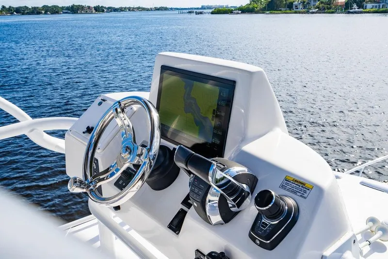 Slide: The Image of Intrepid 477 Evolution 2022 boat helm with navigation screen and controls on a sunny day. - 26