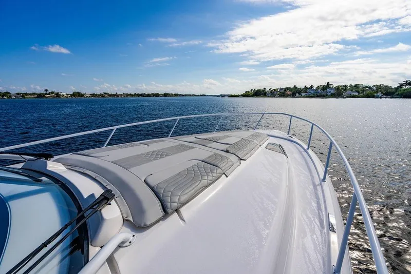 Slide: The Image of 2022 Intrepid 477 Evolution yacht cruising on a sunny day, with scenic waterfront views. - 28