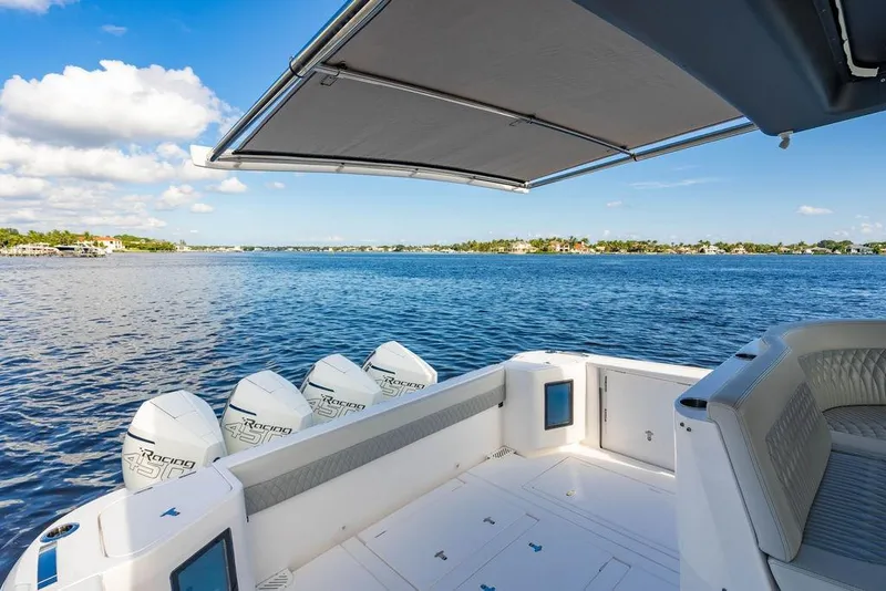 Slide: The Image of 2022 Intrepid 477 Evolution boat with four engines, spacious deck, and scenic water view. - 7