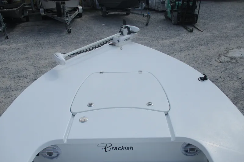 Slide: The Image of 2022 Brackish 19 boat deck with trolling motor in a gravel lot. - 5
