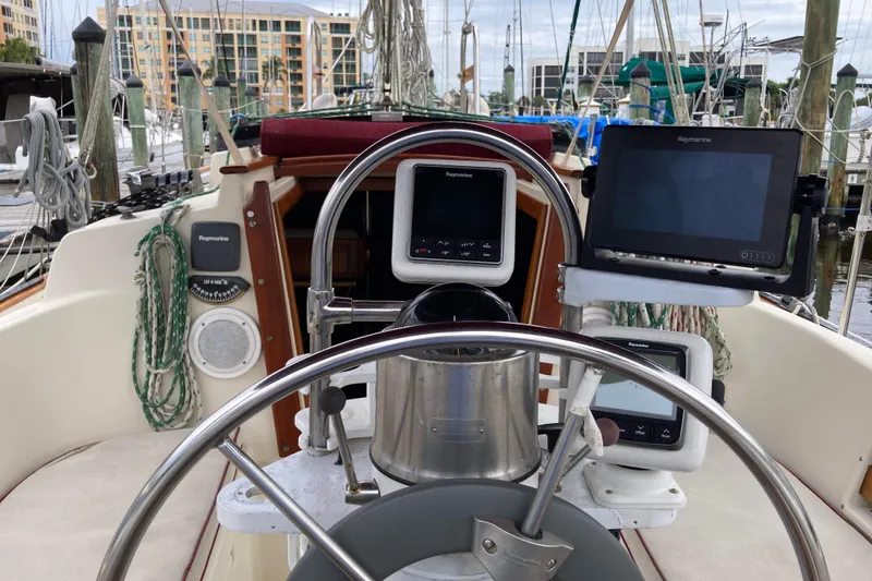 Slide: The Image of Cockpit of 1990 Pacific Seacraft 34 Voyager with navigation equipment and steering wheel. - 11