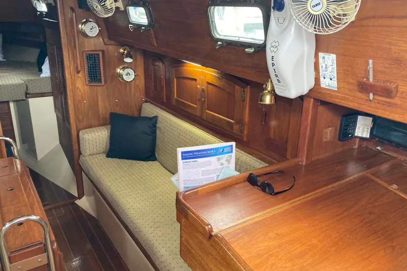 Slide: The Image of Interior of 1990 Pacific Seacraft 34 Voyager sailboat with wooden furnishings and seating area. - 16