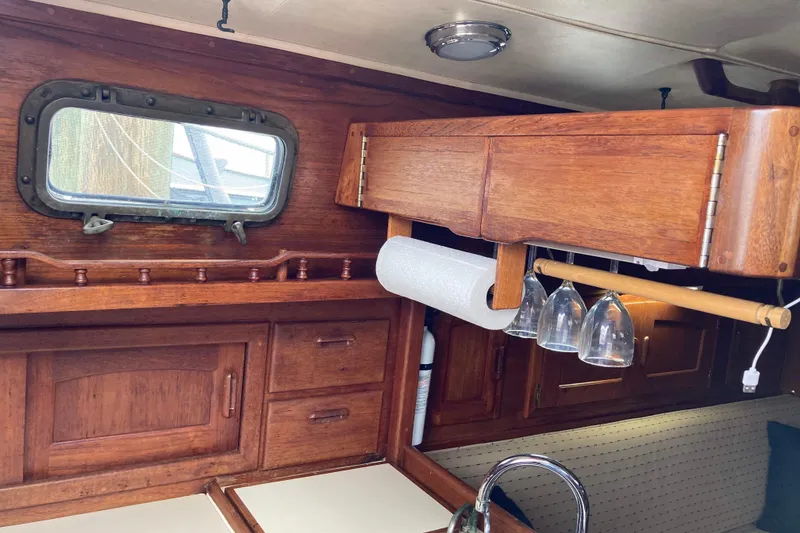 Slide: The Image of Interior of 1990 Pacific Seacraft 34 Voyager with wooden cabinetry and porthole window. - 19