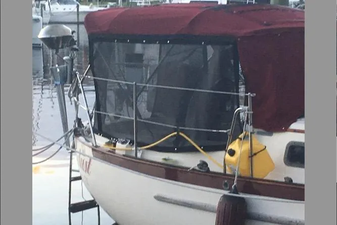 Slide: The Image of 1990 Pacific Seacraft 34 Voyager sailboat with maroon canopy docked at marina. - 33