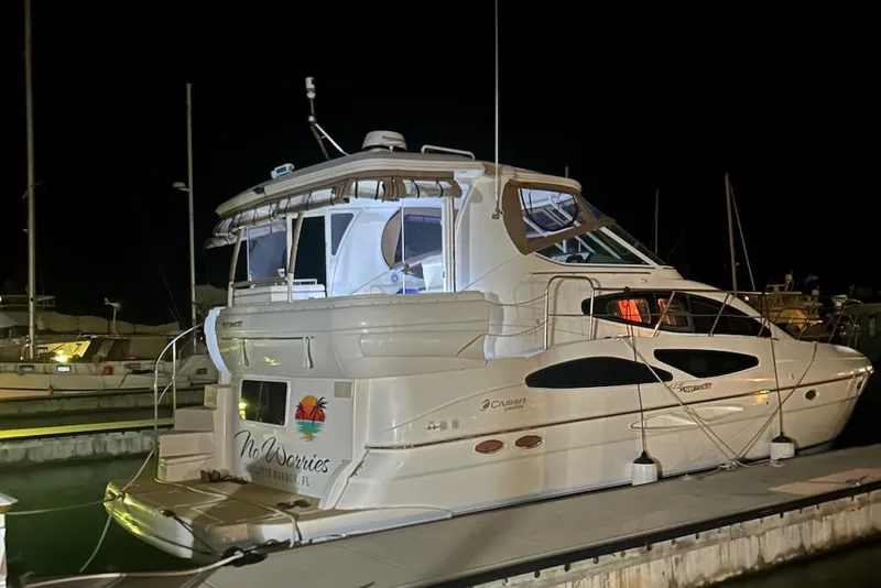 Slide: The Image of 2006 Cruisers Yachts 415 Express Motoryacht docked at night, illuminated and serene. - 2