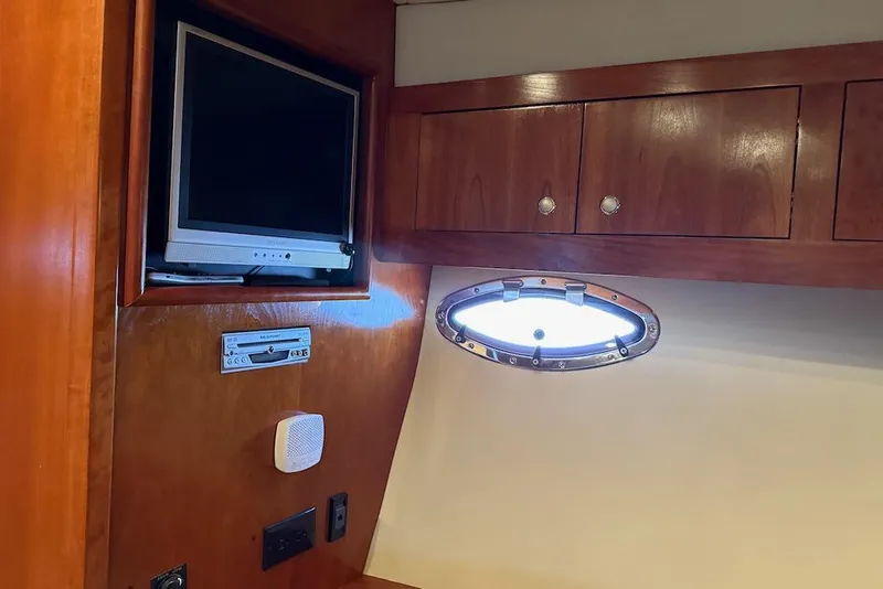 Slide: The Image of 2006 Cruisers Yachts 415 Express Motoryacht interior with TV, DVD player, and porthole. - 26