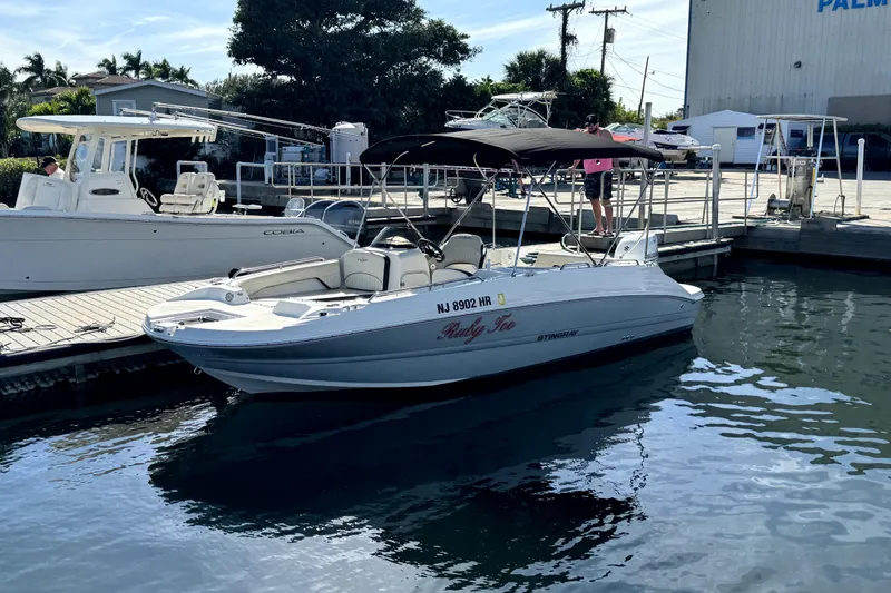 The Image of 2022 Stingray SC192 boat docked at marina, sunny day, calm water. - 1