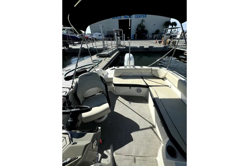 Slide: The Image of 2022 Stingray SC192 boat interior with seating and steering wheel at marina. - 13