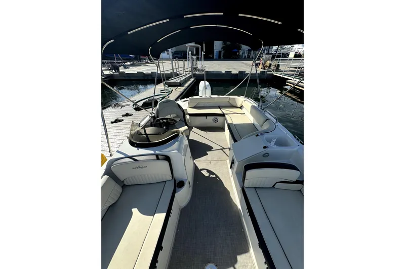 Slide: The Image of 2022 Stingray SC192 boat interior with seating and canopy at a marina. - 14