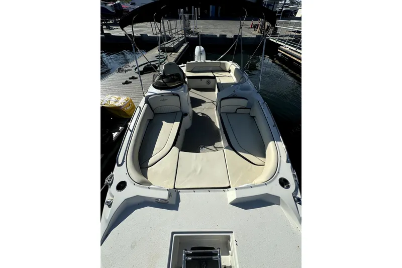 Slide: The Image of 2022 Stingray SC192 boat with spacious seating and canopy, docked at marina. - 16