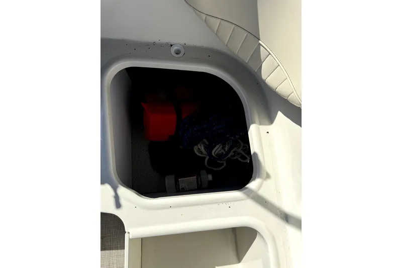 Slide: The Image of Storage compartment in 2022 Stingray SC192 boat with rope and red container. - 18