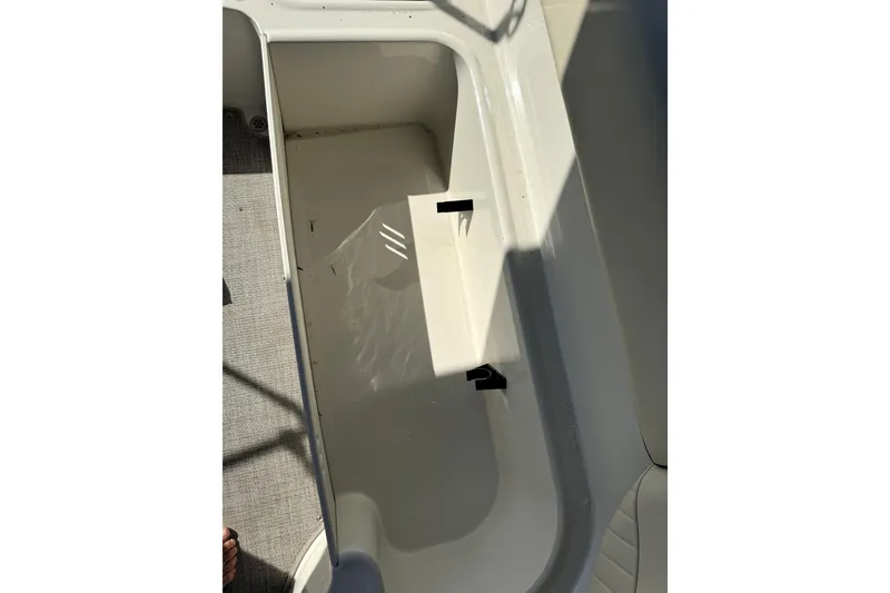 Slide: The Image of 2022 Stingray SC192 boat storage compartment, open and empty, with sunlight casting shadows. - 19