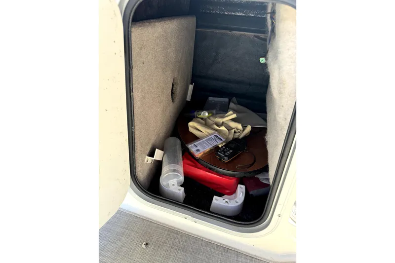 Slide: The Image of Storage compartment of 2022 Stingray sc192 boat with various items inside. - 20
