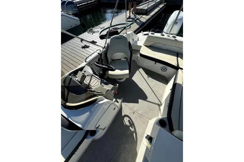 Slide: The Image of 2022 Stingray sc192 boat interior with seating and steering wheel at dock. - 27