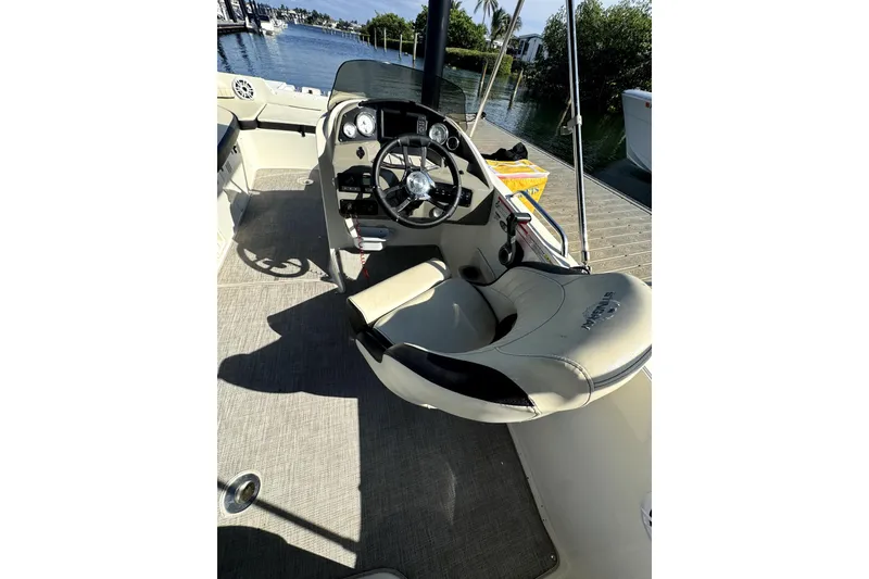 Slide: The Image of 2022 Stingray SC192 boat interior with steering wheel and seating, docked by the water. - 5