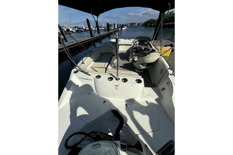 Slide: The Image of 2022 Stingray SC192 boat docked at marina, interior view with steering wheel. - 9