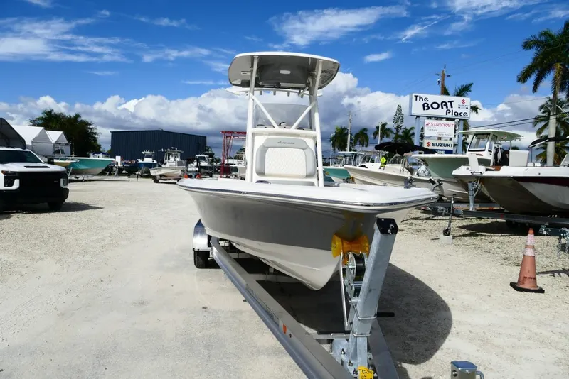 Slide: The Image of 2026 Avenger AV26 boat on trailer at dealership, under clear blue sky. - 15