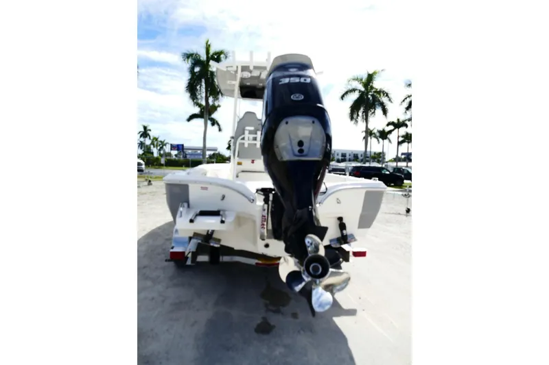 Slide: The Image of 2026 Avenger AV26 boat with powerful outboard motor, parked outdoors under palm trees. - 17