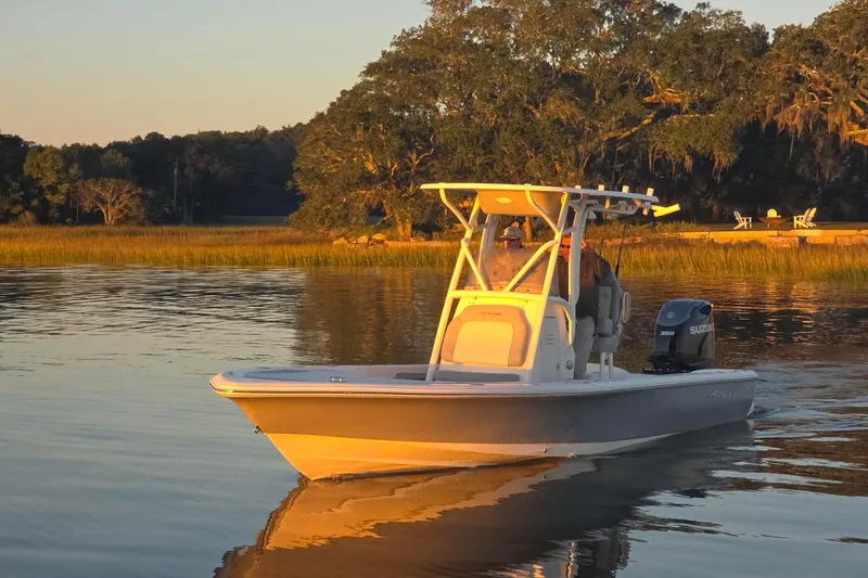 Slide: The Image of 2026 Avenger AV26 boat cruising on a serene lake at sunset. - 2