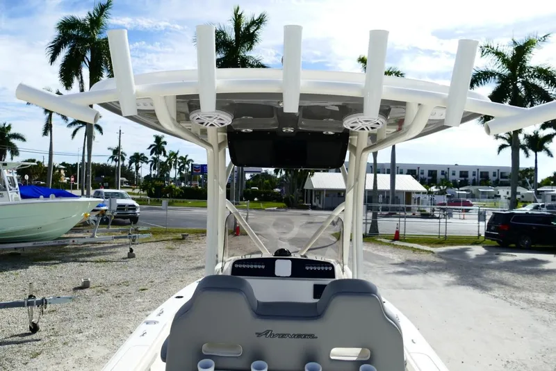 Slide: The Image of 2026 Avenger AV26 boat with T-top and rod holders, parked near palm trees. - 21