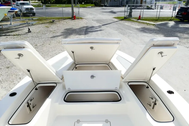 Slide: The Image of Open storage compartments on a 2026 Avenger AV26 boat, parked on gravel. - 38