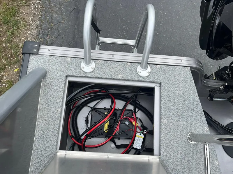 Slide: The Image of 2025 Lowe Deck SD224 boat battery compartment with cables and ladder. - 32